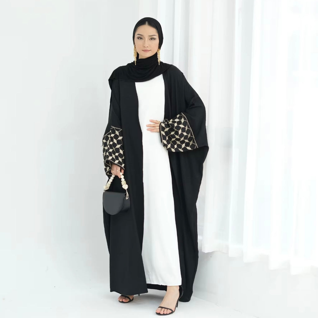 Woman wearing a black and white outfit with a patterned sleeve on a white background